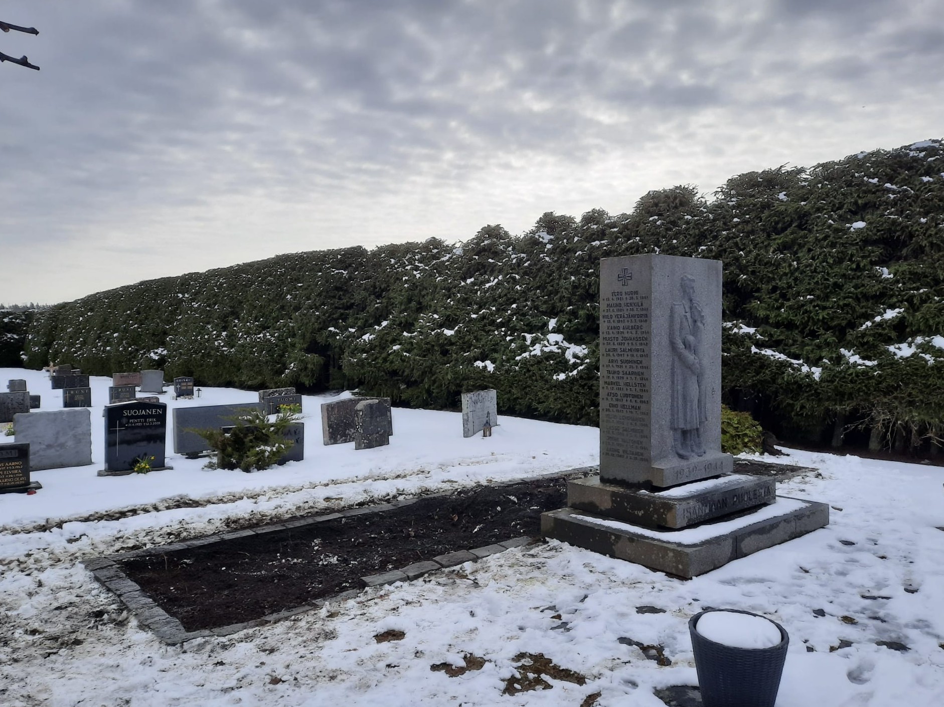 Sankarivainajien muistomerkki lumisella hautausmaalla.