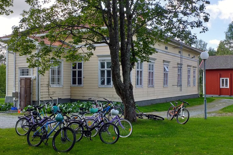 Keltainen pappila, jonka edessä polkupyöriä nurmikolla