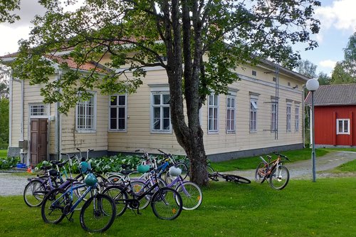 Keltainen pappila, jonka edessä polkupyöriä nurmikolla